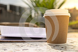 Unrecognizable Young woman study in beach resort. Drinking coffee from paper cup. Student making homework Female hands