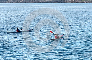 Unrecognized people canoeing in the sea in the morning. People exercising in the ocean