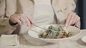 Unrecognized woman going to eat beautifully served appetite buckwheat noodles with arugula and cherry tomatoes. Close up
