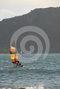 Unrecongizable people enjoying a sail on a colorful catamaran in Mazatlan, Mexico