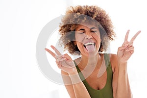 Unretouched portrait of body positive girl stick out tongue make v sign  light studio color background