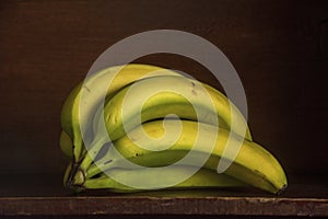 Unripe Bananas Sitting on a Shelf