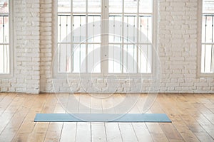 Unrolled yoga mat in empty fitness studio