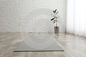 Unrolled yoga mat on floor in room