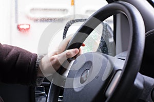 Unsafe one hand driving the car`s steering wheel