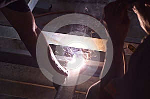 Unsafe Welder Working with no Protection Uniform, Weld Metal with Arc Welding Machine in the Construction Site