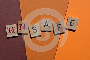 Unsafe, word in wooden alphabet letters