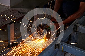 Unsafe Worker Cutting Metal Construction with no Protection Uniform with Electric Wheel Grinding Machine in the Construction Site