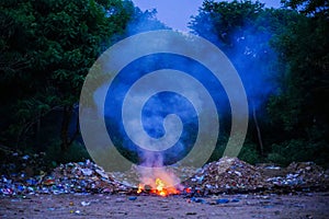 Unscientific burning of garbage in a public place in a late evening photo