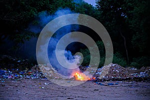 Unscientific burning of garbage in a public place in a late evening photo