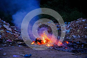 Unscientific burning of garbage in a public place in a late evening photo