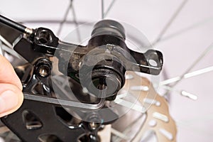 Unscrewing the brake shoe of the bicycle brake caliper with a hexagon. Replacement of brake pads, close-up