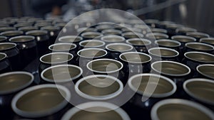 Unsealed Cans Of Beer On Conveyor In Production Line. close up