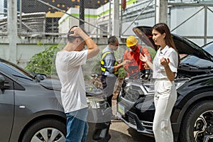 An unset young woman talking angryly to a man who accidentally drove his car and hit her car photo