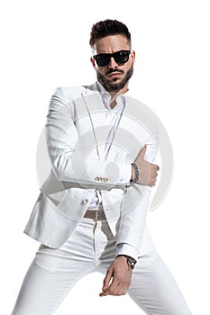 Unshaved businessman with sunglasses posing in a cool manner