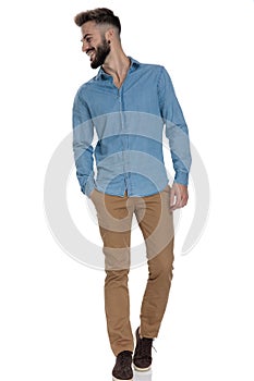 Unshaved hipster standing with hand in pocket and looking away