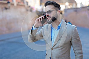 unshaved young man talking on the phone and looking to side