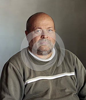 Unshaven man with shaved head with critical eye