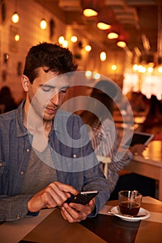 Unshaven millennial texting in a restaurant