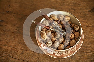 Unshelled walnuts in a plate on a wooden background. view from above. place for text