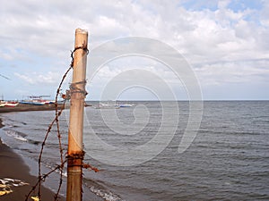 Unsightly a bamboo pole and barbed wire were left on inundated seashore caused by strong ocean waves of typhoons.