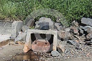 Unsightly drainage ditch placed on the shoreline of the Pacific Ocean photo