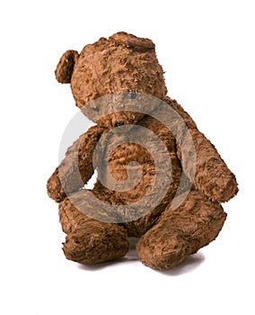 Unsightly sad vintage teddy bear. sitting on a white background photo