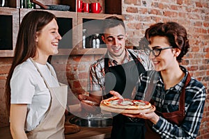 Unskilled cook present pizza to his friends photo