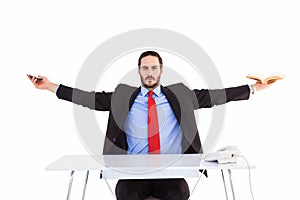 Unsmiling businessman sitting with arms outstretched
