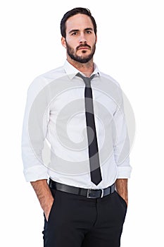 Unsmiling businessman standing with hands in pockets photo