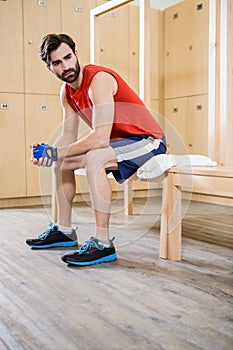 Unsmiling man sitting in locker room