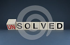 Unsolved or solved. Cubes form the choice words Unsolved or solved