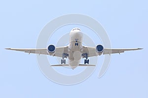 Unspecified white plane on the blue sky and white clouds.