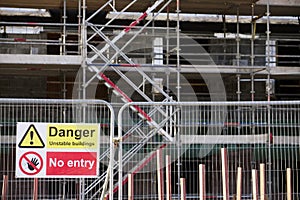 Unstable building keep out dangerous sign on fence at building construction site