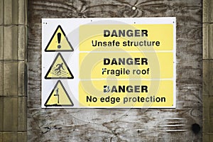 Unstable building keep out dangerous sign on fence at building construction site