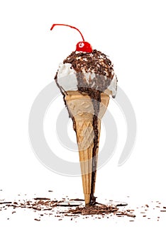 unstable waffle cone with white scoop, chocolate glaze and decorated chips and maraschino cherry of ice cream isolated on white