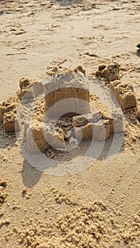unstructured broken sand castle made by kids on beach photo