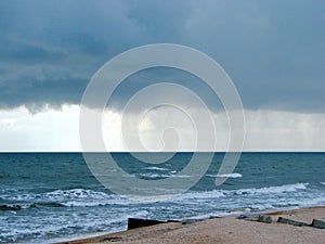 The unsurpassed beauty of the sea coast against the background of rain clouds during a thunderstorm.