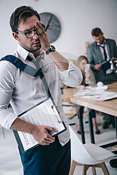 untidy overworked businessman with contract