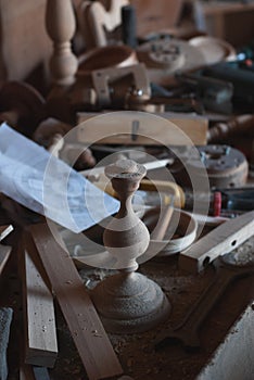 Untidy workplace in an old carpenter workshop with wood carpenter tools in the background, scattered vintage tools in a