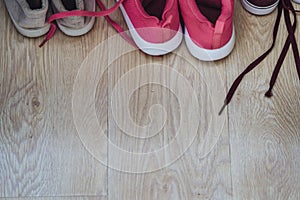 Untied Pink and Grey Shoes on Parquet with Space for Text