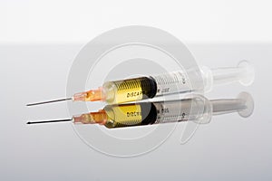 Syringe with Yellow Liquid and Reflection
