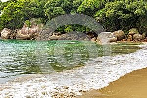 Untouched and deserted beach, surrounded by rocks, rainforest