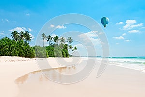 Untouched tropical beach. Empty vacation island coast with palm trees and hot air balloon