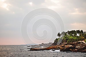 Untouched tropical beach with rocks in the water and white waves in Sri Lanka