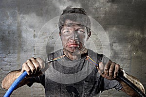 Untrained man joining cable suffering electrical accident with dirty burnt face shock expression
