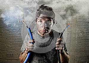 Untrained man joining electrical cable suffering electrical accident with dirty burnt face in funny shock expression