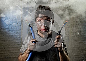 Untrained man joining electrical cable suffering electrical accident with dirty burnt face in funny shock expression