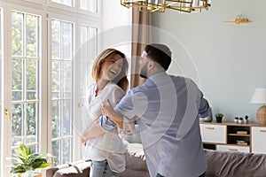 Untroubled couple in love dance together at modern home photo