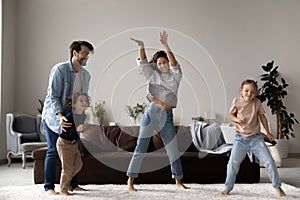 Untroubled family with children dancing together in living room photo